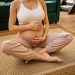 a pregnant woman touching her baby pump