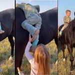 Little girl helps kid brother ride a horse